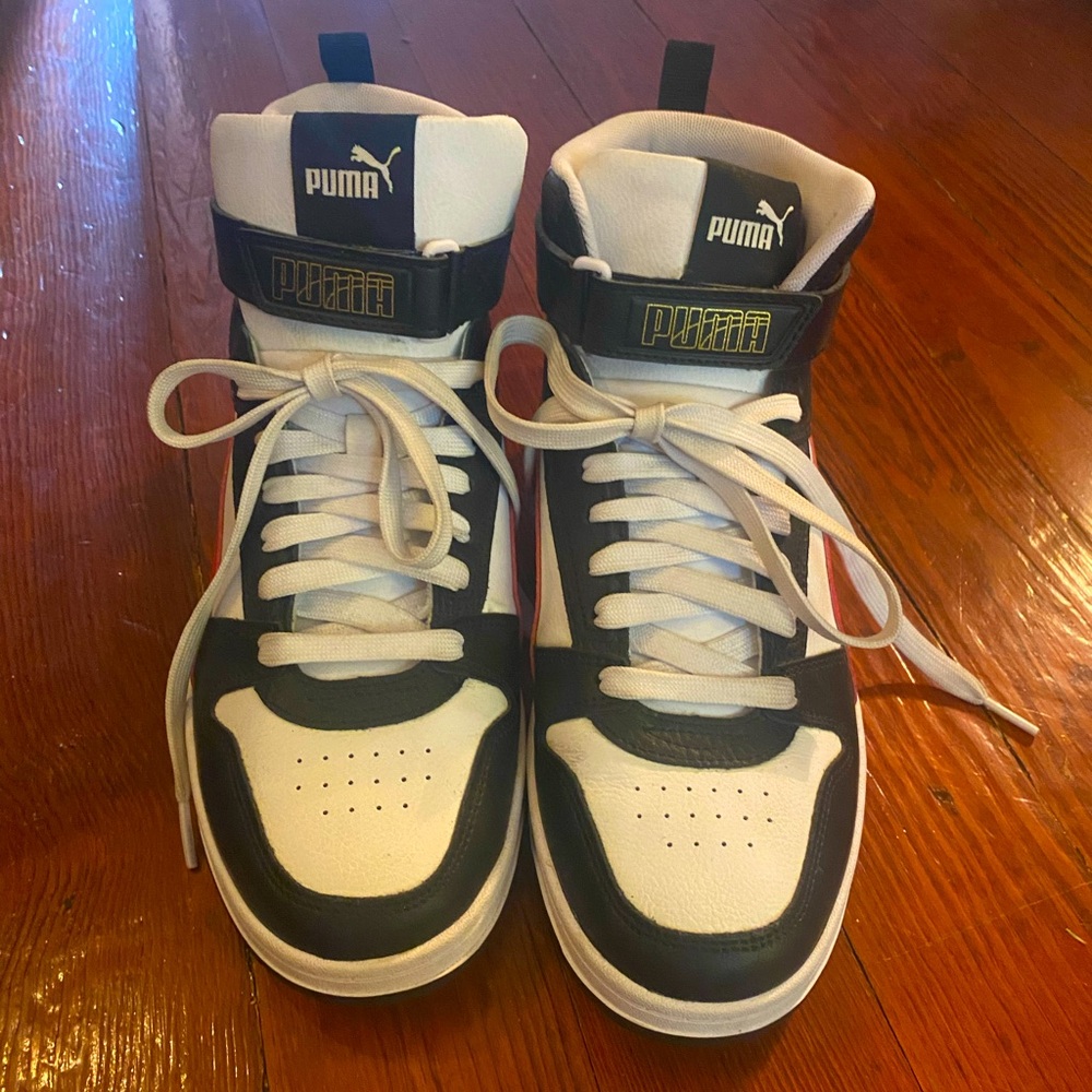 A pair of size 9 red, black, and white high top Puma sneakers